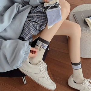 Detail of preppy plaid bow socks with blue-grey contrast and Have a nice day label