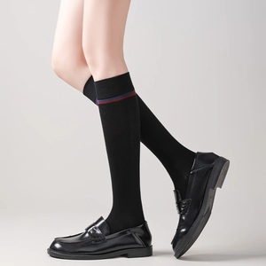 Close-up of black knee-high socks with red and blue stripes and ribbed knit texture