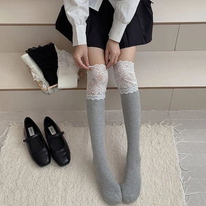 Detail of dark grey knit over-the-knee socks with white lace trim and ballet style design