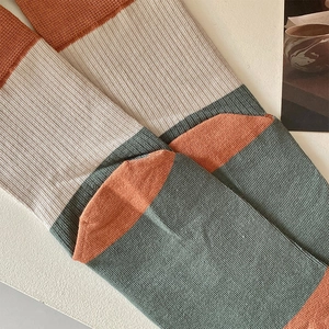 Close-up of ribbed knit texture on two-toe cotton socks in vintage color-block style
