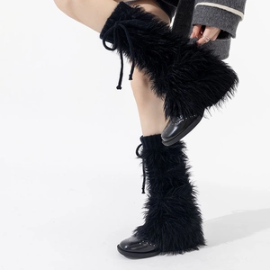 Détail de jambières en fausse fourrure noire avec nœuds réglables pour un style JK chic