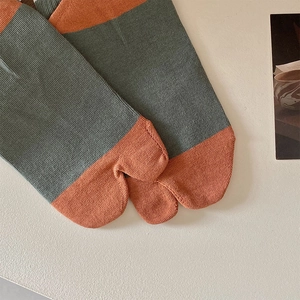 Close-up of contrast striped Tabi socks with split-toe detail and ribbed knit texture