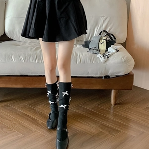 Detailed texture of black knit calf socks with 3D white bows and multi-color options