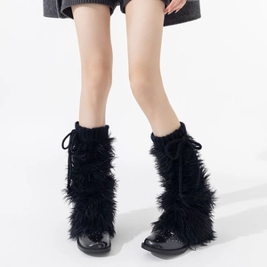 Détail de jambières en fausse fourrure noire avec cordon de serrage tricoté et nœud