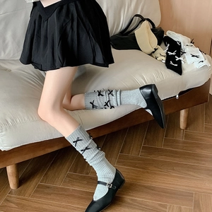 Detail of ballet style calf socks with black bows and vertical ribbed knit texture