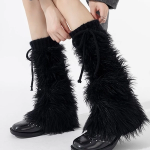 Détail de jambières noires en fausse fourrure avec nœud de serrage et poignets en tricot