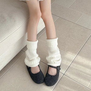 Close-up of white ribbed knit leg warmers paired with grey Mary Jane shoes