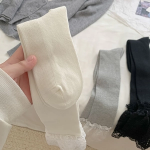 Close-up of ribbed texture and delicate lace trim on ballet style high calf socks