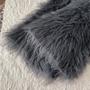 Close-up of thick dark grey faux fur leg warmers with soft long plush texture