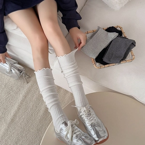 White ruffled ribbed leg warmers in ballet style with multiple color options in a basket