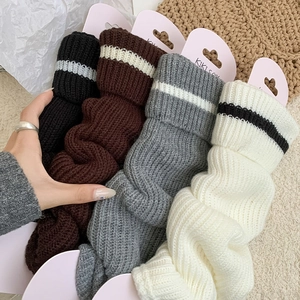 Close-up of knit leg warmers showing ribbed texture and striped cuff detail
