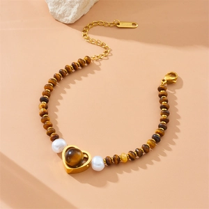 Tiger eye stone beaded bracelet with gold heart pendant and pearls on cream background