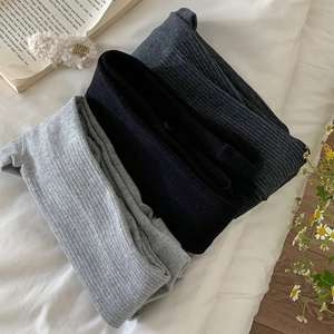 Detailed close-up of ribbed knit tights in light grey, black, and dark grey textures