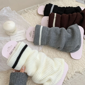 Detailed knit texture of striped leg warmers in black, coffee, gray and beige colors