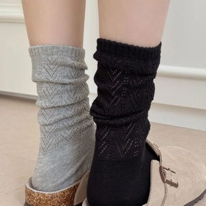 Close-up of pointelle knit socks in black and grey with delicate V-shaped hollow patterns