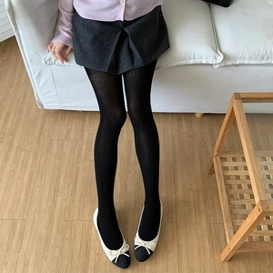 Detailed view of black vertical ribbed tights featuring a soft and stretchy knit texture
