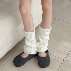 White ribbed knit leg warmers in a slouchy style, styled with wool shoes for fall winter
