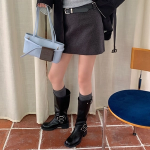 Detail view of stylish grey ribbed calf socks worn with black leather boots and a mini skirt