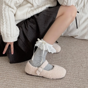 Close-up of grey ribbed socks with white lace trim and ribbon bows with fluffy shoes