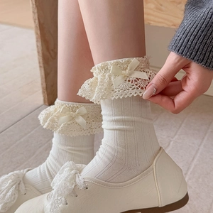 Nahaufnahme weißer Rippstrick-Socken mit zarter Spitze und Schleifendetails aus Satin