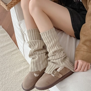 Close-up of beige ribbed knit leg warmers with slit detail for a cozy winter look