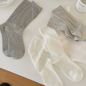 Detail of white and grey mid-calf socks with V-shape hollow knit pattern and soft cotton texture