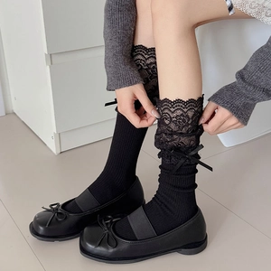 Detail of black lace trim socks with silk ribbon bows paired with Mary Jane shoes