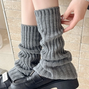 Detail of grey ribbed knit leg warmers with slit design and thick winter texture