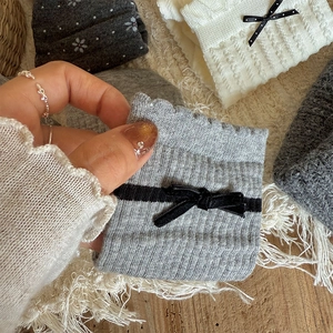 Detailed texture of rib-knitted socks with delicate lace edges and black bow accents