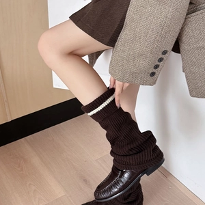 Close-up of dark brown ribbed knit leg warmers with white stripes in a vintage style