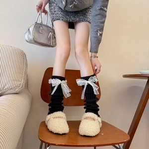Jambières en tricot noir avec nœuds en dentelle blanche et texture à côtes verticales