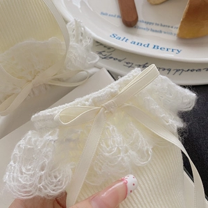 Detailed knit texture of white Lolita socks with delicate lace trim and ribbon bows