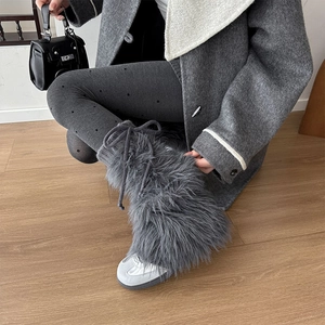 Detail of dark grey faux fur leg warmers with drawstring ribbons and plush texture