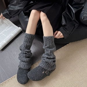 Calentadores de punto gris oscuro con zapatos planos de fieltro para look de invierno