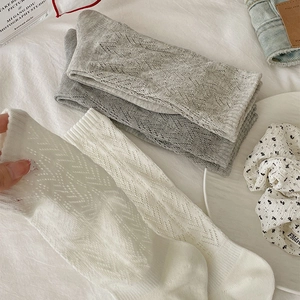 Detail of breathable hollow-out geometric knit pattern on white and grey cotton socks
