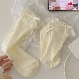 Detail of cream white Lolita socks featuring delicate lace edges and satin ribbons