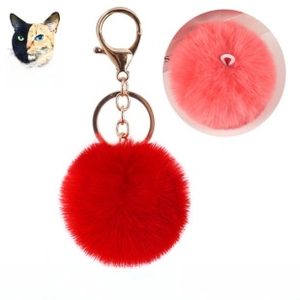 Detail of a 6cm red plush pom pom keychain with a gold metal lobster clasp and ring