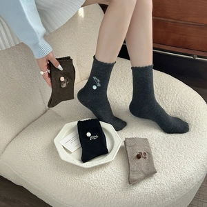 Detail of cotton crew socks with cat embroidery, 3D pom-poms, and ruffled lettuce edges