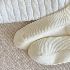 Close-up of cream ribbed knit socks showing high-quality texture and vertical weave detail