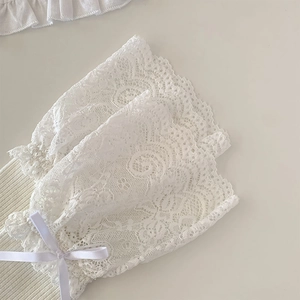Detail of white lace calf socks with delicate bows and intricate floral knitting