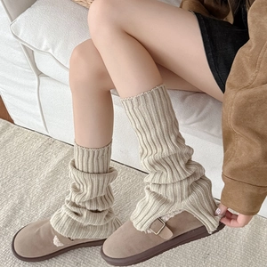 Minimalist beige ribbed knit leg warmers paired with warm brown fuzzy lined mule shoes