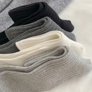 Detailed view of the soft ribbed knit texture on the stack of multi-colored leg warmers