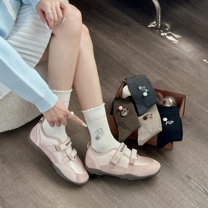 Pink velcro sneakers paired with white ruffle socks featuring cute cat embroidery
