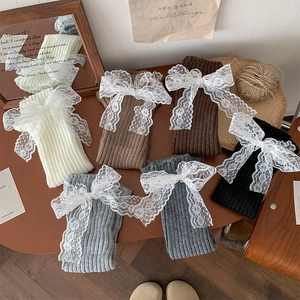 Détail de jambières en tricot Lolita avec nœuds en dentelle en blanc, kaki, brun et noir