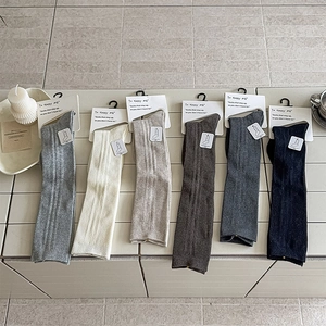 Close-up of vertical ribbed texture on mid-calf socks in six neutral earth tones