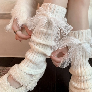 Detail of white knit leg warmer with a large lace bow and ribbed texture in Lolita style