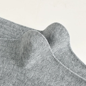 Détail macro de chaussettes montantes grises montrant la texture côtelée et le tissu