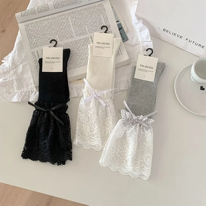 Detail of ballet style lace trim socks with silk bows in black, beige and grey colors
