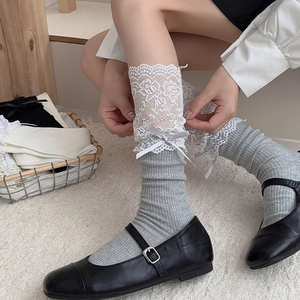 Detail of grey lace trim calf socks with a ribbon bow and elegant ballet style