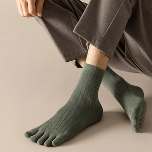 Close-up of sage green five-toe ribbed cotton socks for men on feet in casual style